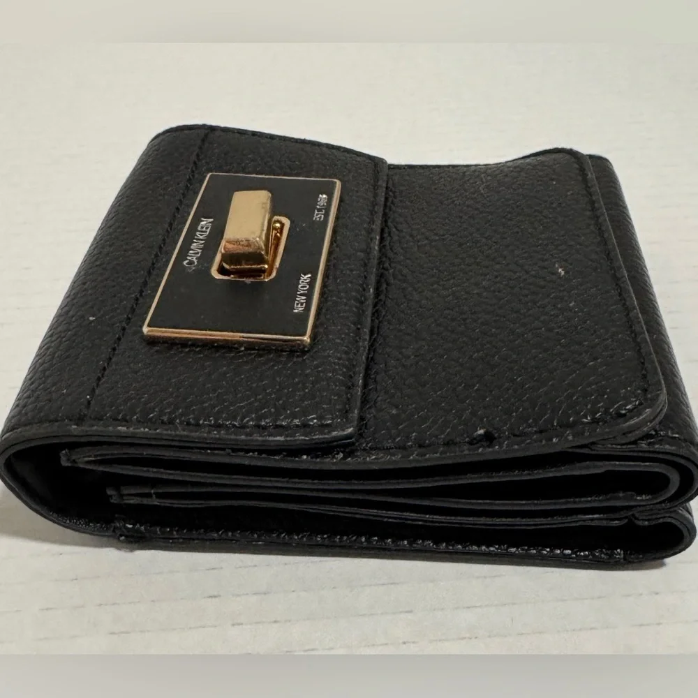 Calvin Klein black trifold wallet with a gold-tone metal closure